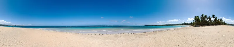 The beach road at Las Terrenas runs past open-air restaurants and calm Atlantic shallows